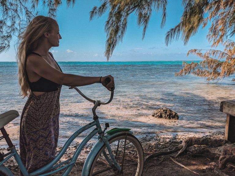 Standing With A Bike Gazing Out At The Ocean In French Polynesia.