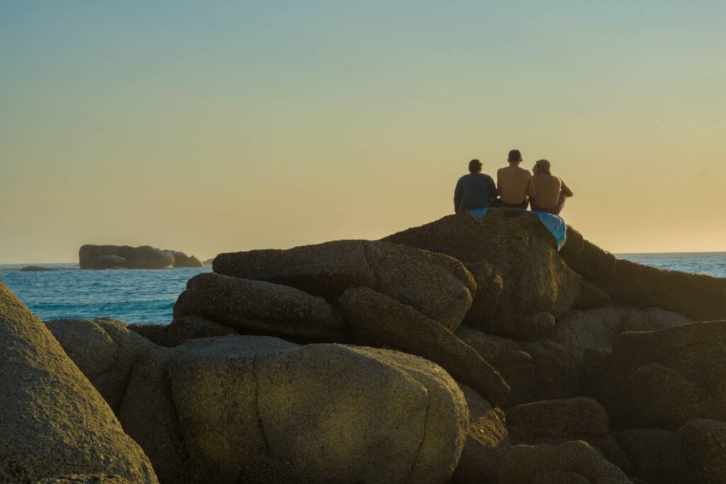 Clifton Beaches at Sunset. People Sitting On A Rock Enjoying The Night on the Beach.