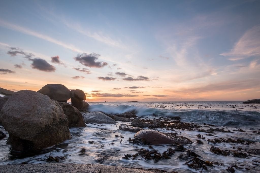 Oudekraal At Sunset With The Waves Crashing Into The Rocks.
