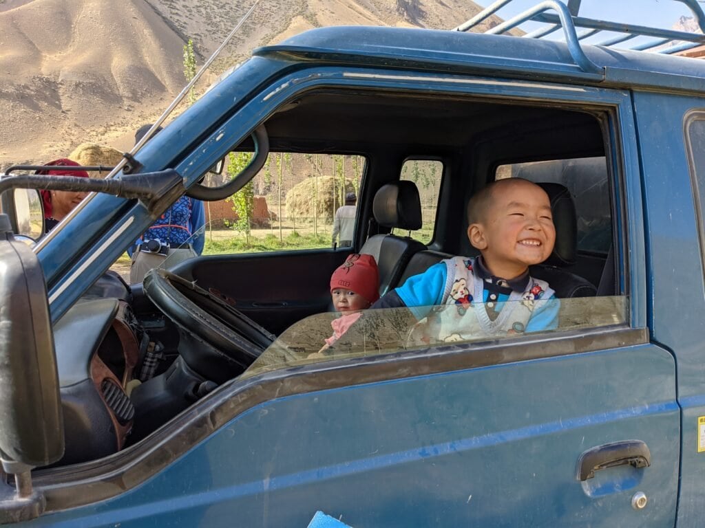 A Young Local Boy and Toddler Playing In A Truck In Kyrgyzstan.