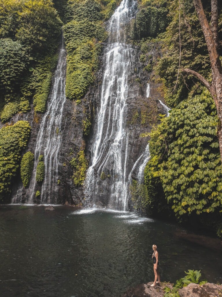 Waterfall in Bali with Laura standing at the base.