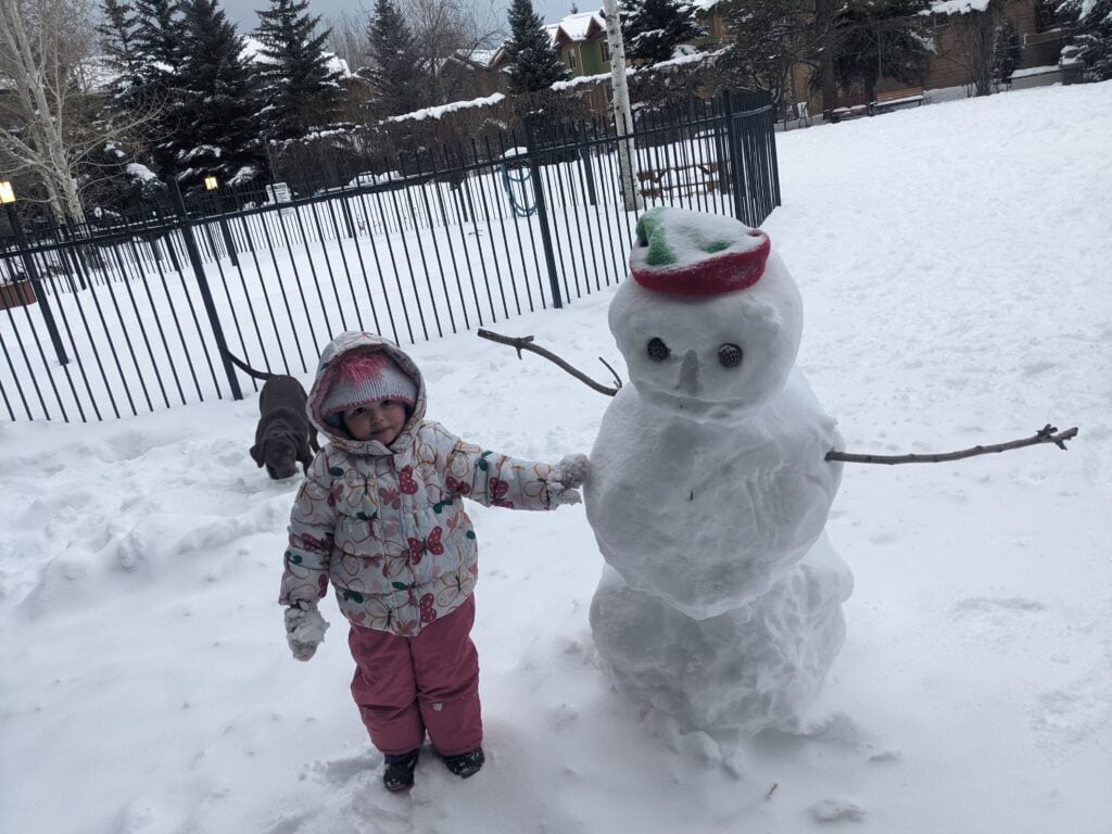 Winter standing next to a snowman in Steamboat Springs, Colorado.