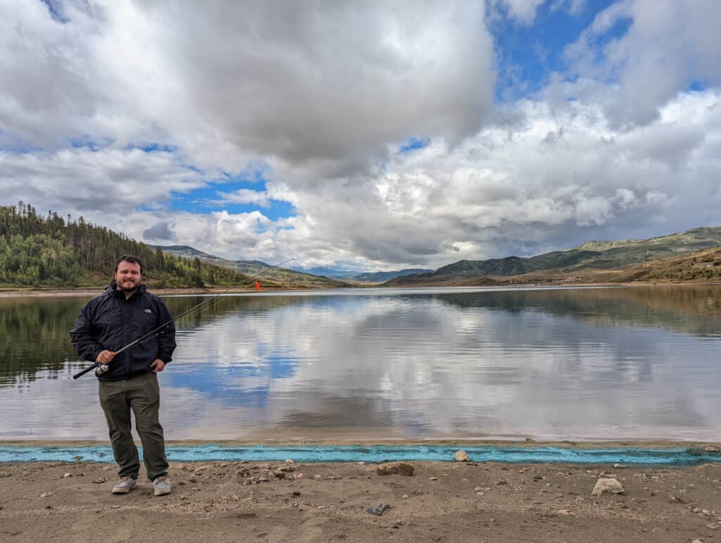 Mike standing near Stagecoach Reservoir with a fishing pole.