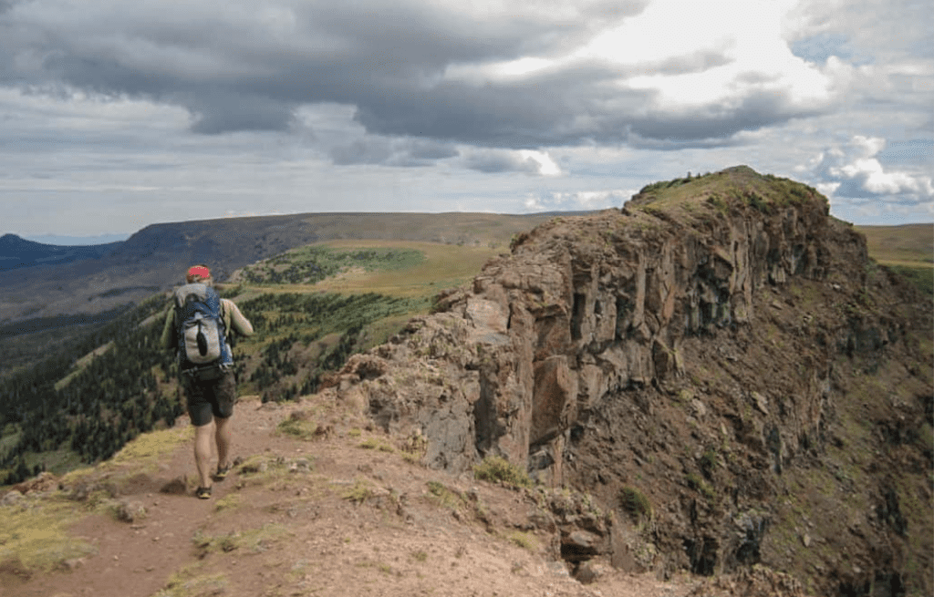 A hiker about to cross Devil's Causeway in Flat Tops Wilderness near Oak Creek.