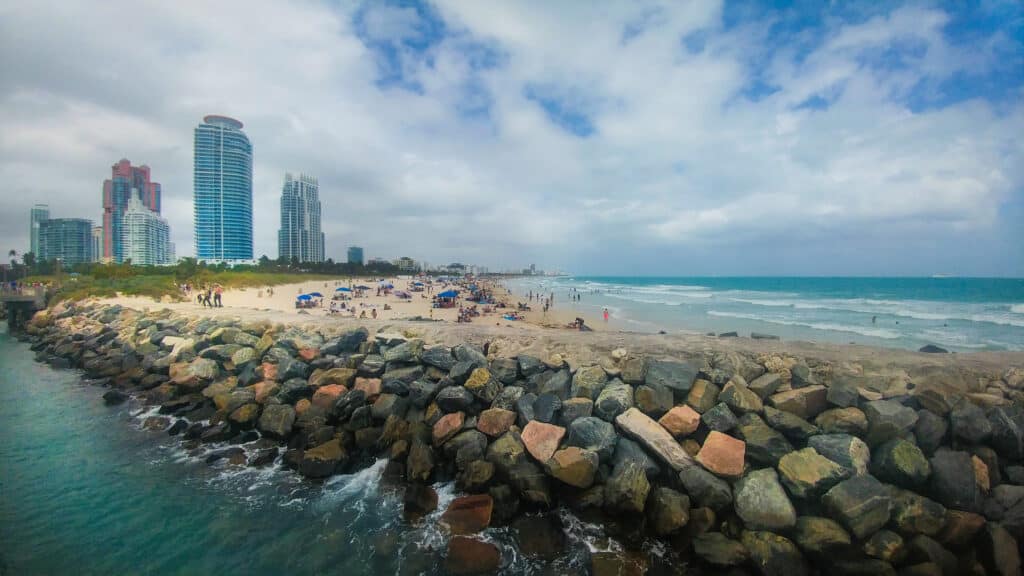 A view of the high rise towers of Miami from the rocky and sandy pier.