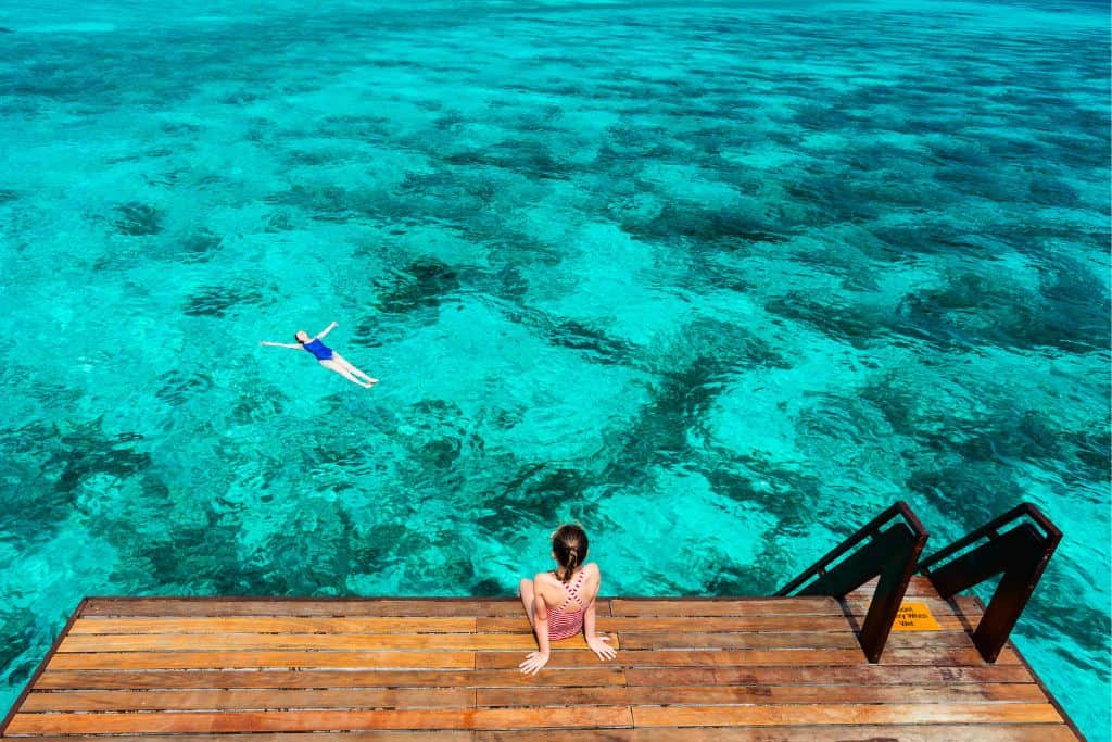 two kid swimming in the ocean maldives