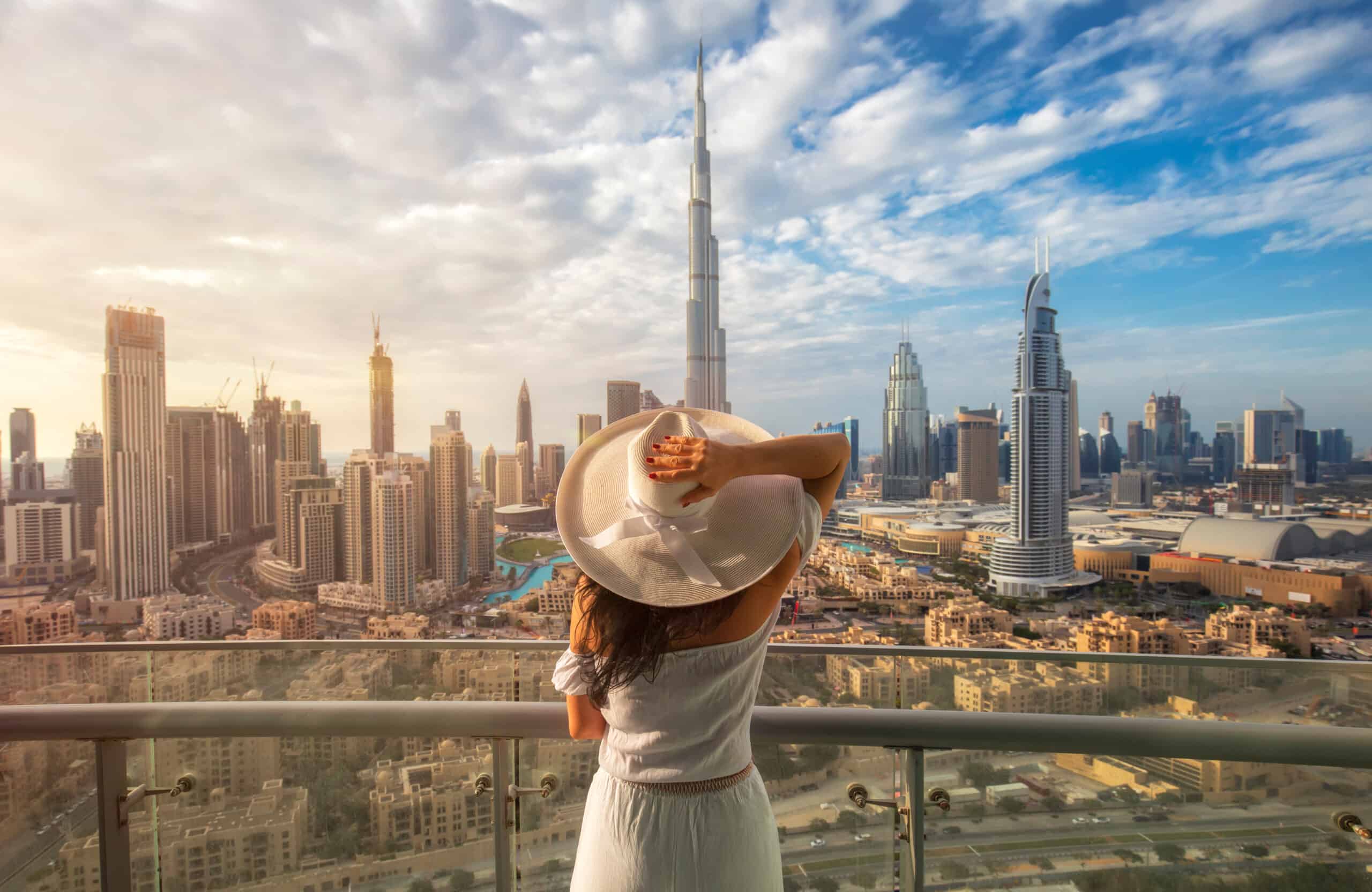 A girl looking out into Dubai with a hat on.
