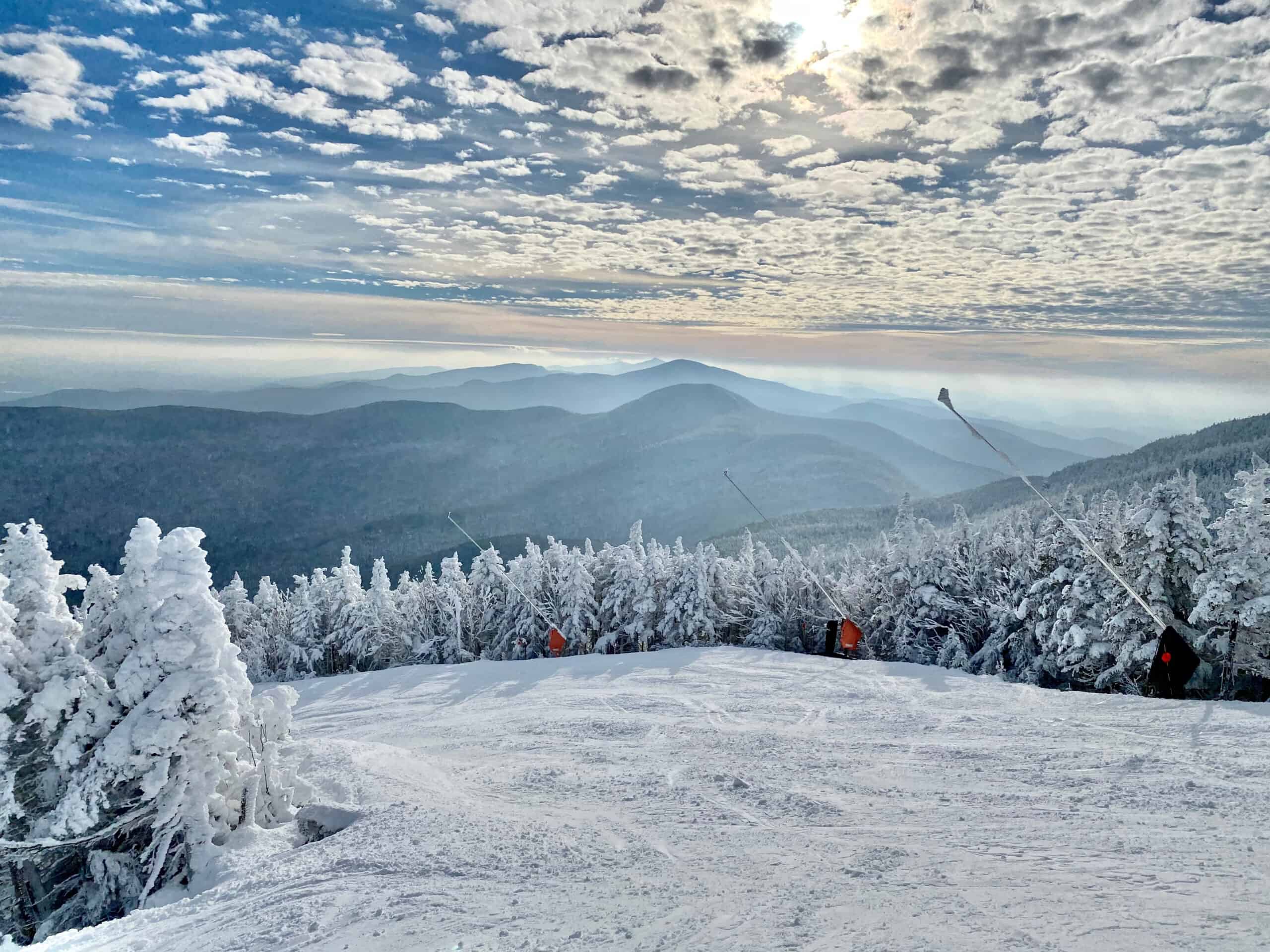 A landscape view at the top of a ski resort on a sunny day.