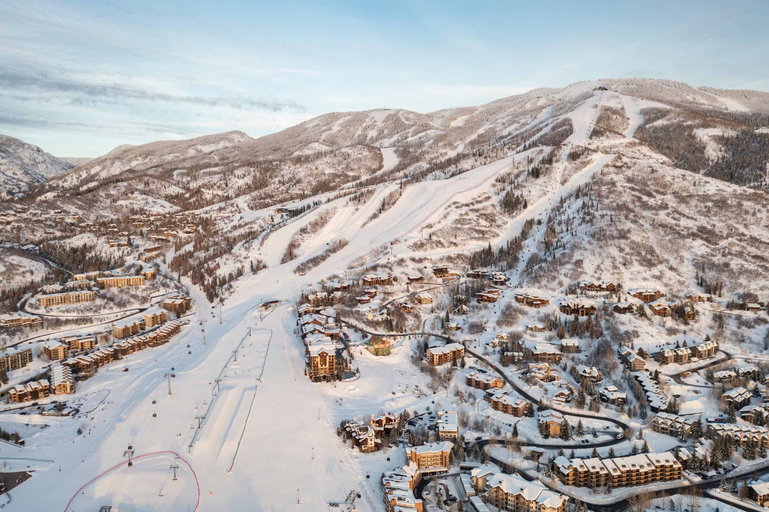 An aerial view over Steamboat Resort with snowy slopes and chalets below.
