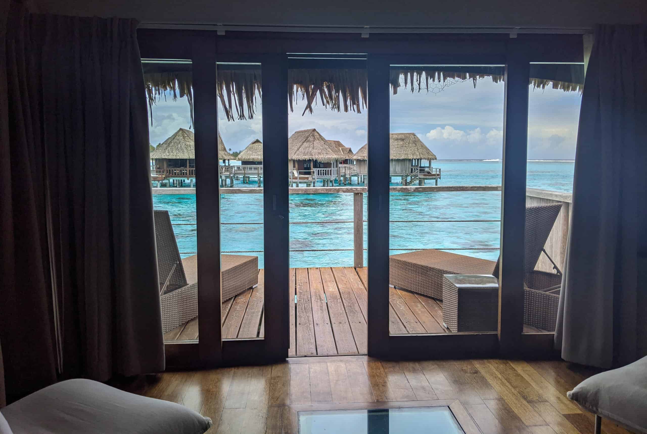 A view from inside the Sofitel Kia Ora Moorea overwater bungalow looking out over the blue lagoon.
