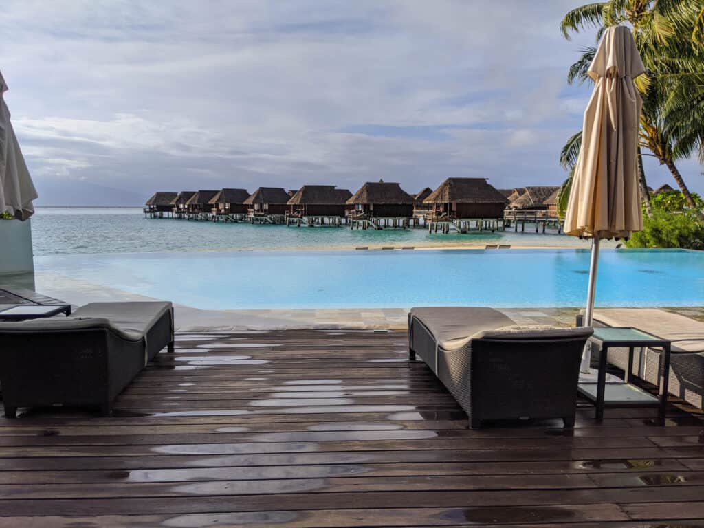 A view over the infinity pool to the lagoon and overwater bungalows at the Sofitel Kia Ora Moorea.