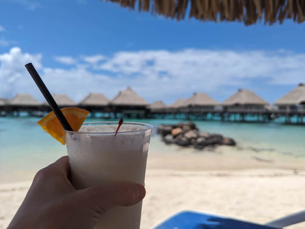 Mike holding a delicious pina colada on the beach at the Hilton Moorea.