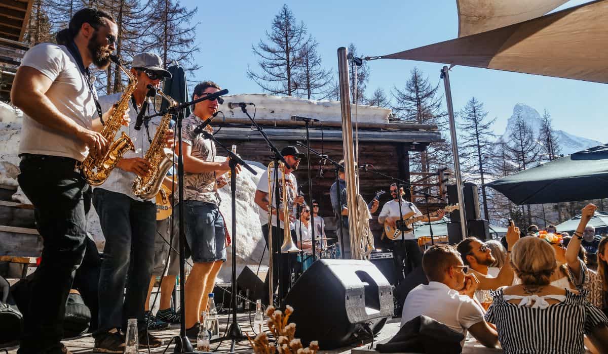 A live brass band playing on stage on a sunny day in Zermatt in winter.
