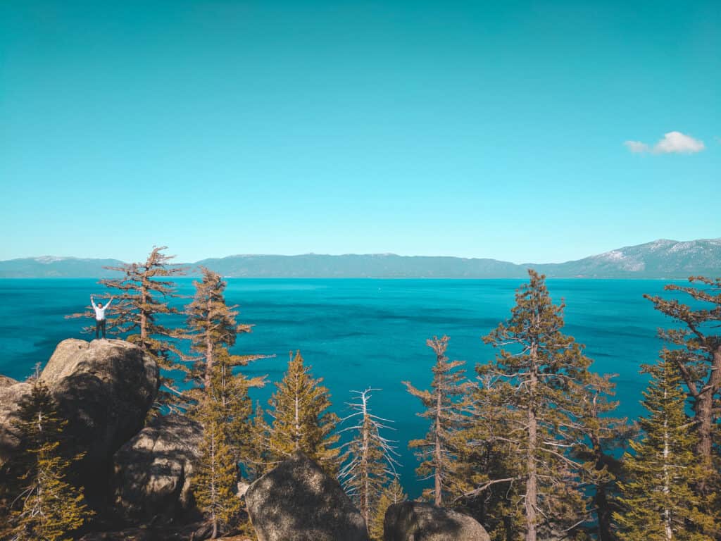 A picture of Mike standing on a rock with the landscape of Lake Tahoe behind him.