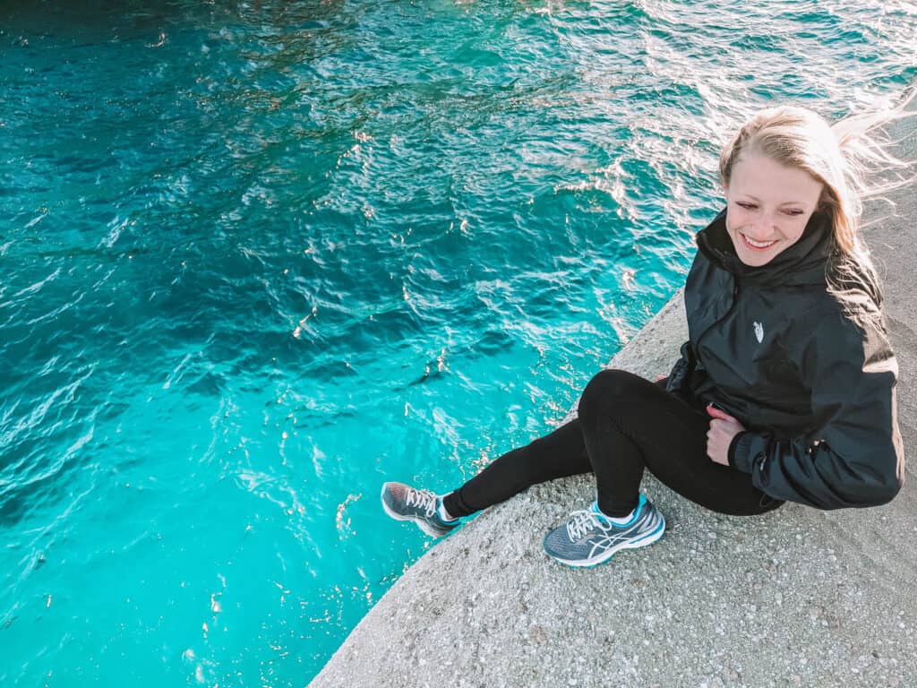 Laura sitting on a rock at Sarakiniko Beach in Milos, Greece