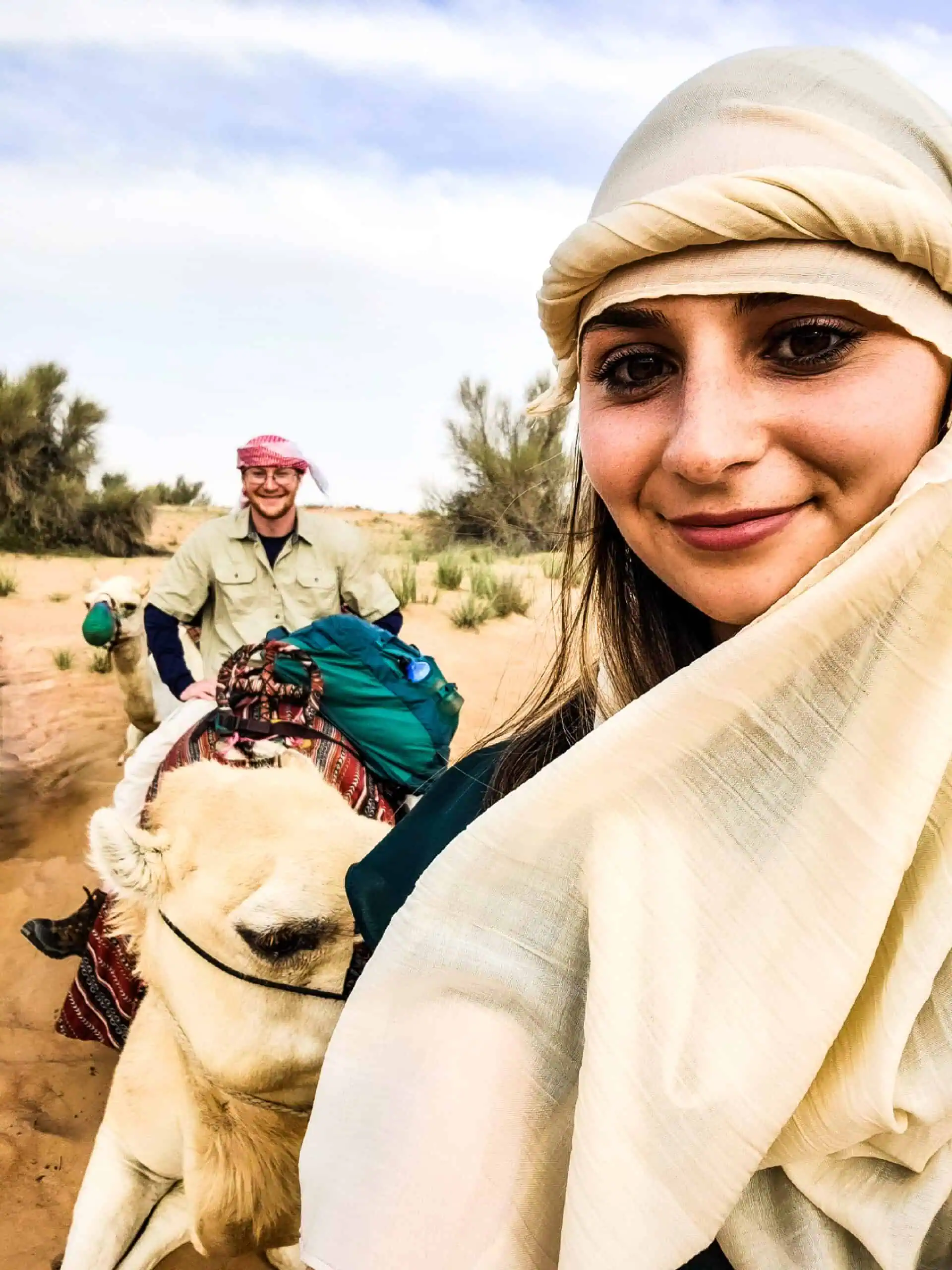 Emily and Sean riding a camel in the desert.