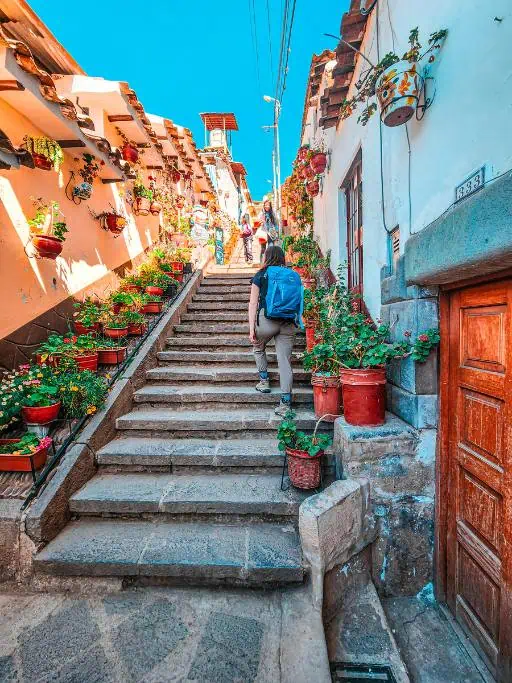 Emily climbing stairs in a neighborhood in Cusco.