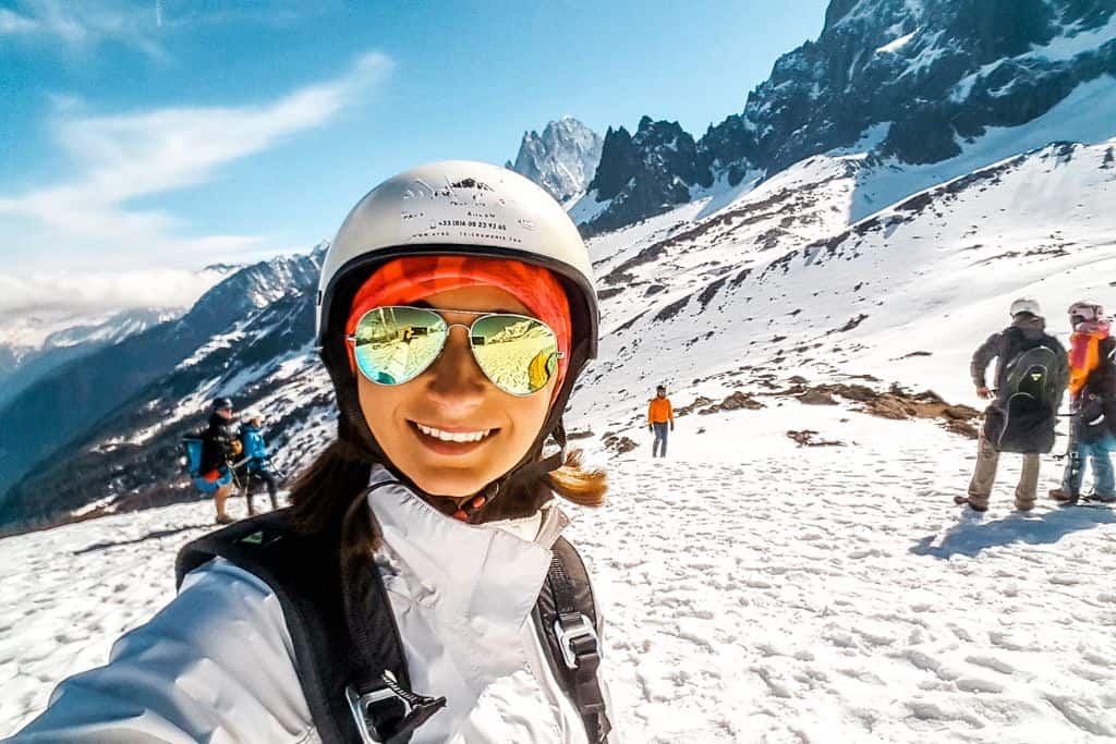 Emily smiling for a selfie on a mountain while traveling.