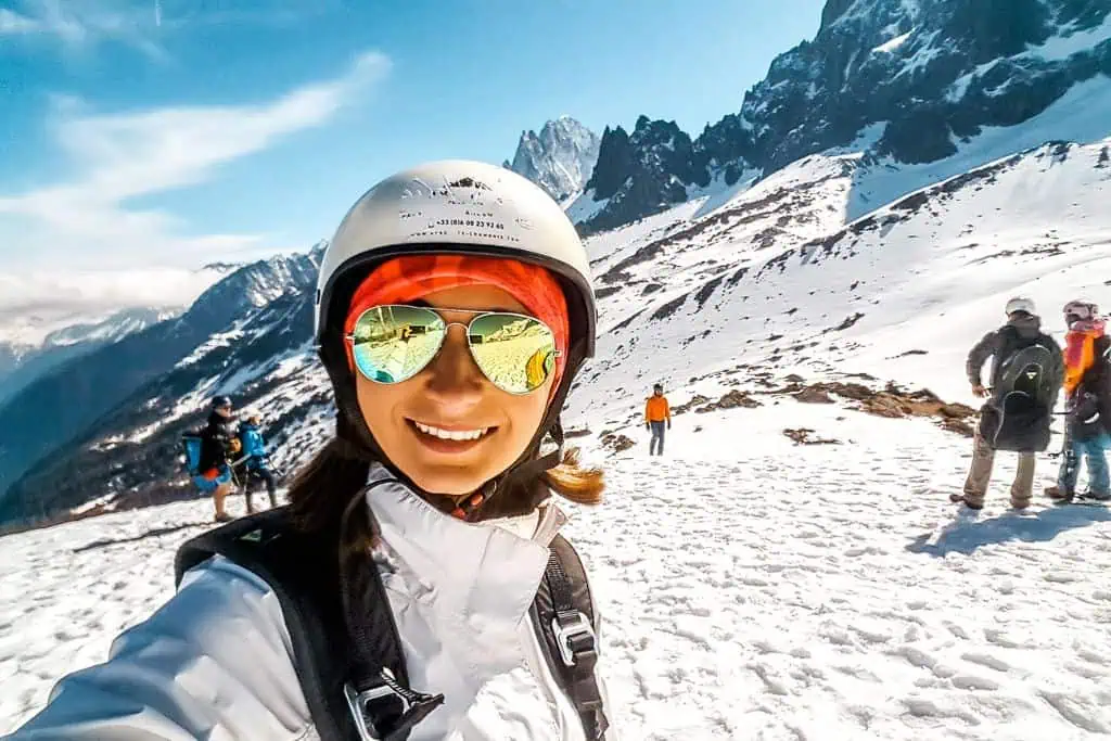 Emily smiling for a selfie on a mountain while traveling.