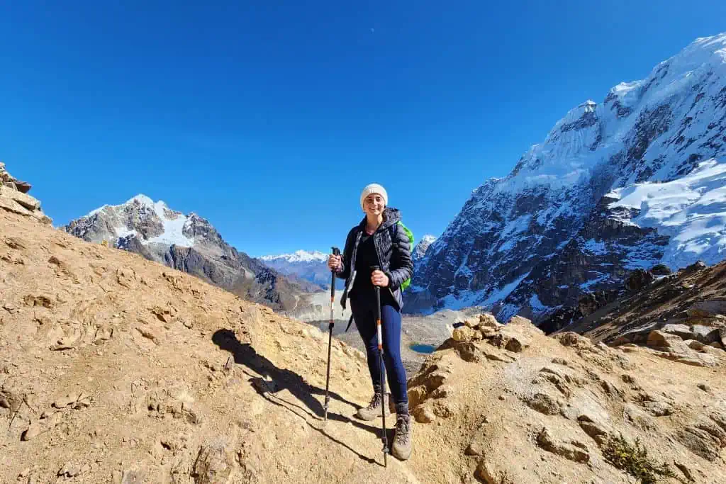 Emily standing at the top of a mountain smiling for the camera.